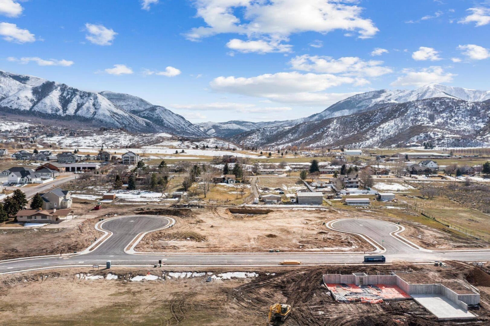 Aerial view of a construction site with mountains in the background, located in Southern Utah Valley.