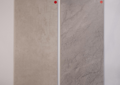 A pair of marble tiles with custom red dots on them.