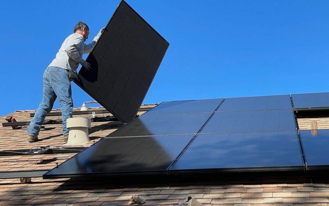 A man installing solar panels on a Southern Utah Valley roof.